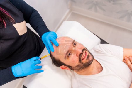 Top view of a man receiving treatment for hair implants