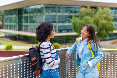 Téléchargez les photos : Photo horizontale avec espace de copie de deux femmes souriantes multiraciales parlant sur le campus universitaire - en image libre de droit