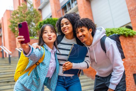 Retrato de bajo ángulo de vista de ti estudiantes universitarios guays multi-étnicos tomando una selfie en el campus