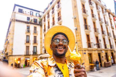 African american happy man eating an ice cream taking selfie in the city