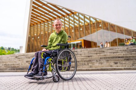 Full length low angle view portrait of a happy caucasian adult man with cerebral palsy smiling proud outside the university