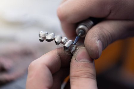 Téléchargez les photos : Dental technician works by brush with jaw model. Facial Dental Prosthetic - en image libre de droit