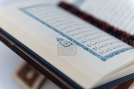 Téléchargez les photos : Les mots du Coran sont des mots arabes qui signifient le Saint Coran. Perles musulmanes et coran sur table en bois. Concept islamique. - en image libre de droit
