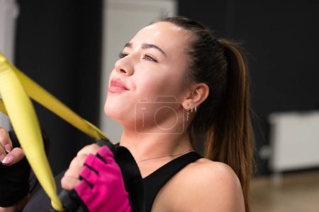 Foto de Joven hermosa mujer deportiva está haciendo ejercicios en una sala de fitness. Entrenamiento en el gimnasio - Imagen libre de derechos