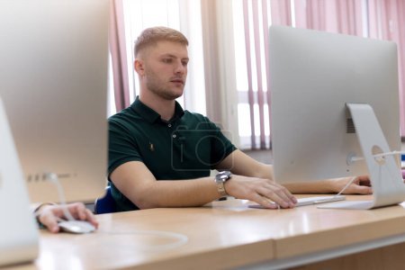 Foto de Hombre joven en la escuela de programación.Estudiante masculino que aprende en una clase de programación - Imagen libre de derechos