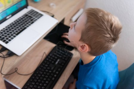 Foto de Un niño jugando juegos en PC en su casa - Imagen libre de derechos