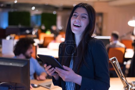 Photo for Female programmer working in office at night - Royalty Free Image