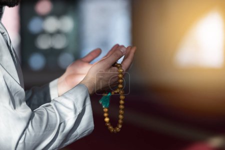 Photo for Hand of male muslim praying with mosque interior background during ramadan - Royalty Free Image