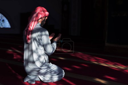 Téléchargez les photos : Main de musulman mâle priant avec le fond intérieur de la mosquée pendant le ramadan - en image libre de droit