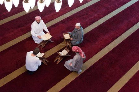 Foto de Lea el Corán el día del Ramadán. Grupo de jóvenes musulmanes leyendo el Corán en la mezquita - Imagen libre de derechos