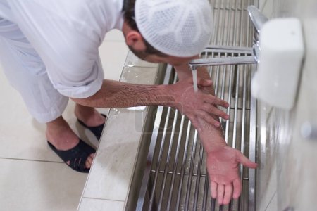 Téléchargez les photos : Homme musulman effectuer ablution ou wudu à la mosquée. Laver avant de prier - en image libre de droit