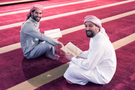 Foto de Lea el Corán el día del Ramadán. Dos jóvenes musulmanes leyendo juntos el Corán en la mezquita - Imagen libre de derechos