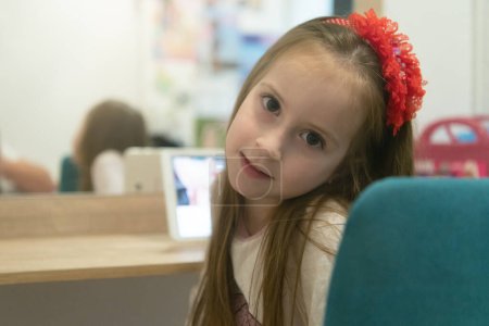 Téléchargez les photos : Petite fille utilisant son ordinateur portable dans sa chambre - en image libre de droit