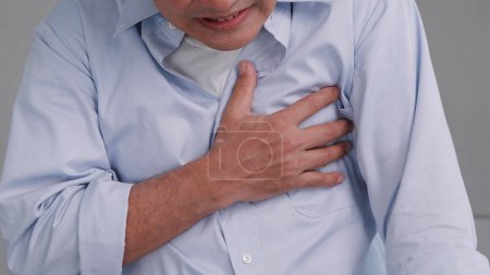 Hombre asiático tiene dolor en el pecho causado por enfermedades del corazón.
