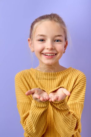 Photo for Lovely kid girl 12-13 years old in yellow shirt blow air kiss isolated on purple background, children studio portrait. Childhood lifestyle concept. emotional kid is in love, posing at camera - Royalty Free Image