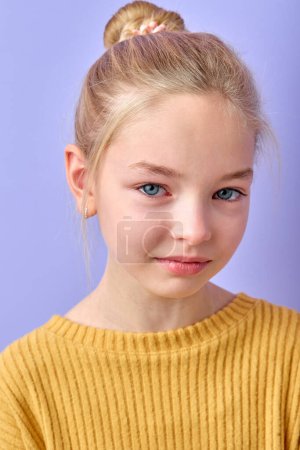 Photo for Portrait of beautiful young blonde woman crying with tears smiling on camera in studio on purple background. Charming cute child in yellow shirt is stressed, sad and offended - Royalty Free Image