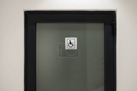 Téléchargez les photos : Porte fermée avec signe de toilette pour handicapés - en image libre de droit