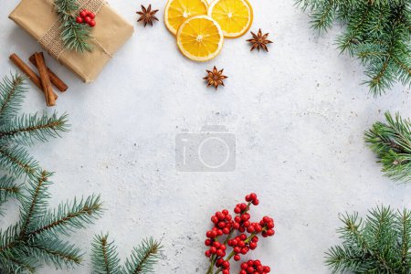 Photo for Christmas decorations with holly berries and tree branches on table. - Royalty Free Image