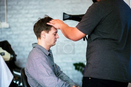 Foto de Joven adulto hombre pelo corto en peluquería para cortar su cabello con pelo profesional mujer elegante, Pequeña empresa en la ciudad. - Imagen libre de derechos