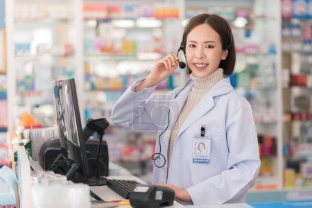Photo for Beautiful smiling young asian pharmacist wearing headset to telemedicine online service with patient. - Royalty Free Image