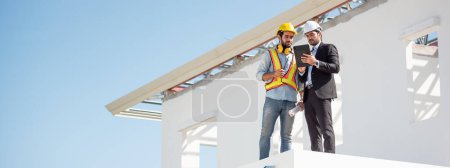 Photo for Panoramic construction engineer and architect team working together with blueprints discuss onthe rooftop outdoor at construction site. - Royalty Free Image