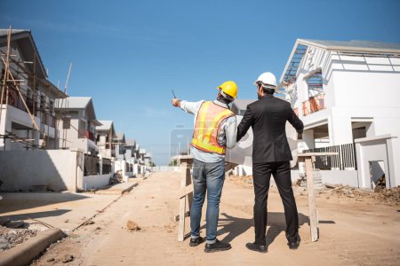 Téléchargez les photos : Ingénieur civil professionnel et architecte en casque de sécurité casque dur travaillant ensemble sur le chantier, deux hommes discutent du projet immobilier ou de la production dans l'industrie - en image libre de droit