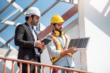 Photo for Construction engineer and technicial team working together and discuss about solar cell project on factory rooftop at construction site. - Royalty Free Image