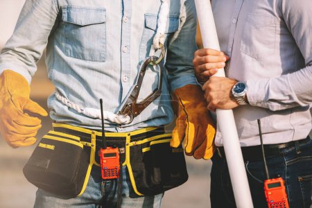 Photo for Close up two caucasian man construction worker and project manager wearing hardhat and safety equipment working together at construction site. - Royalty Free Image