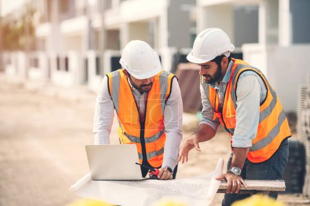 Photo for Two Caucasian man Construction engineers and architects working together at construction site using laptop and blueprints on table. Real estate work site project. - Royalty Free Image
