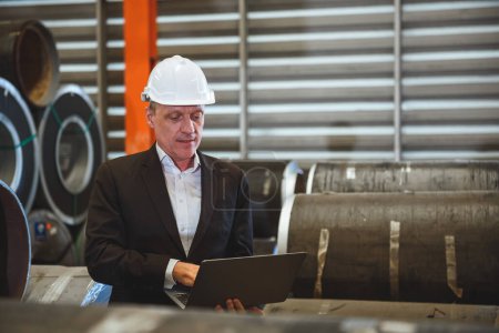 Photo for Senior factory engineering manager using laptop to checking metal sheet inventory and quality control in metal sheet factory. - Royalty Free Image