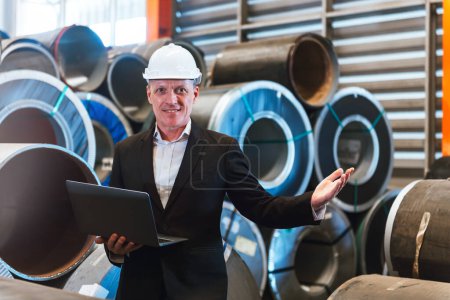 Photo for Factory manager in safety hard hat walking throught production line for inspect machine in factory. Heavy metal industry manufacturing factory. - Royalty Free Image