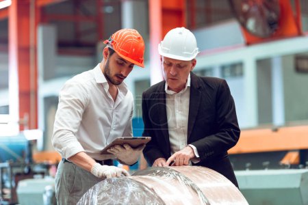Photo for Factory worker engineer wearing protective helmets using tablet for inspect machine system in factory. Heavy metal industry manufacturing factory. - Royalty Free Image