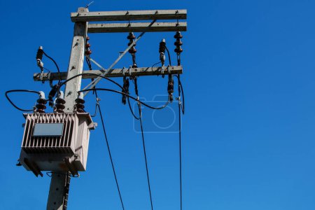 Photo for Electrical poles equipped with large power transformers The background is a bright blue sky. - Royalty Free Image
