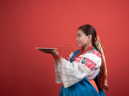 Chica hispana de origen Kichwa con un fondo rojo y sosteniendo una placa para colocar un objeto.
