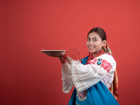 Hispanisches Mädchen Kichwa-Ursprungs mit rotem Hintergrund und einer Gedenktafel, um einen Gegenstand zu platzieren.