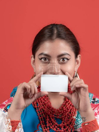 lächelndes ecuadorianisches Latina-Mädchen zeigt eine Kreditkarte in Mundhöhe