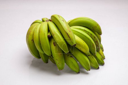 Racimo de plátanos verdes sobre fondo blanco