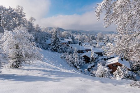 Foto de Nevado y hermoso paisaje invernal en Alttann, en la Alta Suabia. Vista sobre el pueblo cubierto de nieve a la torre de la iglesia - Imagen libre de derechos