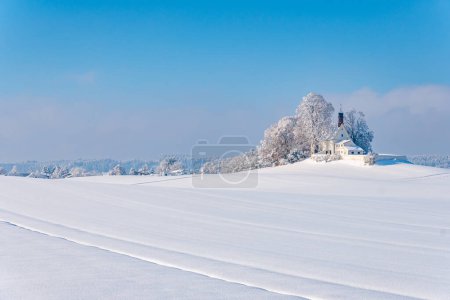 Photo for Snowy and beautiful winter landscape in Wolfegg in Upper Swabia. View to the snow-covered Loreto church - Royalty Free Image