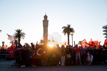 Téléchargez les photos : Izmir, Turquie - 15 juillet 2022 : Journée de la démocratie en Turquie Izmir. Poeple tenant des drapeaux turcs sur la place Konak à Izmir et devant la tour de l'horloge historique. - en image libre de droit