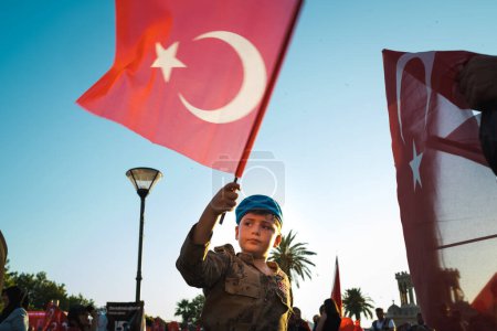 Foto de Izmir, Turquía - 15 de julio de 2022: Un niño con una bandera turca y un traje de soldado en las celebraciones del 15 de julio Día de la Democracia y la Libertad en la Plaza Konak Izmir. - Imagen libre de derechos