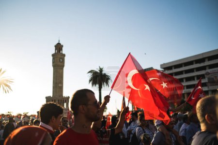 Téléchargez les photos : Izmir, Turquie - 15 juillet 2022 : Journée de la démocratie en Turquie Izmir. Poeple tenant des drapeaux turcs sur la place Konak à Izmir et devant la tour de l'horloge historique. - en image libre de droit