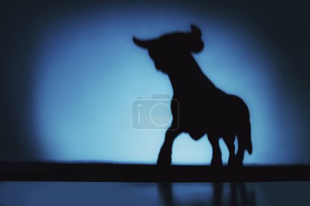 Photo for Shadow of a bull on a blue background. - Royalty Free Image