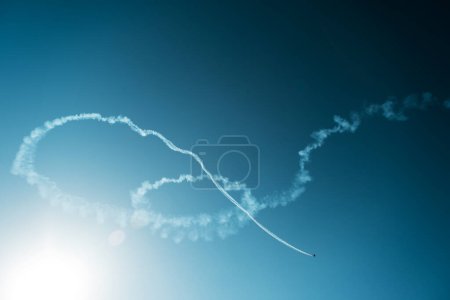 Foto de Humo de un plano acrobático en el cielo azul. - Imagen libre de derechos