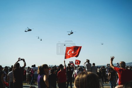 Foto de Izmir, Turquía - 9 de septiembre de 2022: Acercamiento de una bandera turca en el pueblo abarrotado con helicópteros gendarme en el cielo en el día de la libertad de Izmir en Izmir Konak Turquía - Imagen libre de derechos