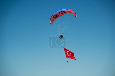 Téléchargez les photos : Izmir, Turquie - 9 septembre 2022 : Jumper paramotor sur le ciel avec un énorme drapeau turc le jour de la liberté d'Izmir à Izmir Konak Turquie - en image libre de droit
