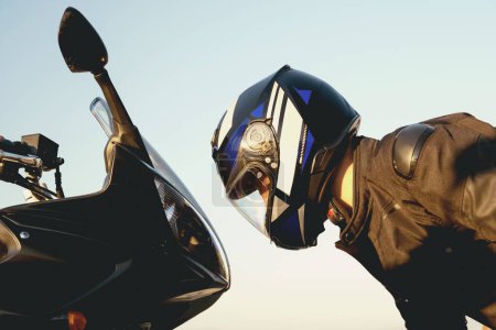 Téléchargez les photos : Cavalier pose avec sa moto supersport tête à tête pose - en image libre de droit