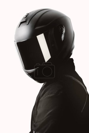 Portrait d'un motard posant avec un casque noir sur fond blanc.