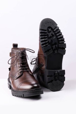 Téléchargez les photos : Une paire de bottes en cuir de couleur marron sur fond blanc. - en image libre de droit
