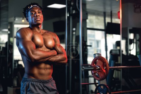 Foto de Retrato de un hombre negro musculoso en un gimnasio con los brazos cruzados. - Imagen libre de derechos
